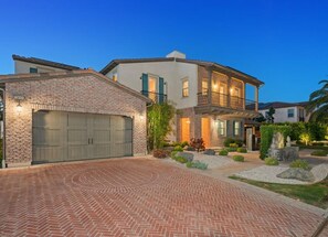 A two-story house with a brick garage and a landscaped driveway.