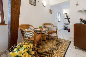 A room with wicker chairs, a small table, and a decorative rug.