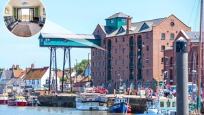A harbor with boats, a large brick building, and a blue structure. - 1 Bed in Wells-next-the-Sea (oc-591) (Wells-next-the-Sea)
