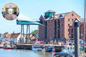 A harbor with boats, a large brick building, and a blue structure. - 1 Bed in Wells-next-the-Sea (oc-591) (Wells-next-the-Sea)
