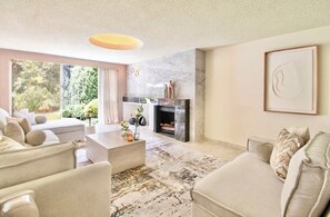 A modern living room with a fireplace, a large window, and a minimalist design. - Curated Polanco Mansion 11BR Luxury Stay Villa (Mexico City)