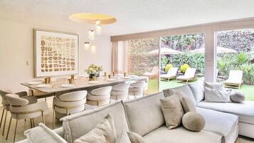 Um interior moderno com área de jantar, sofá e vista para o jardim.