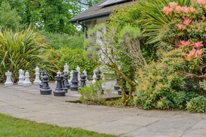 A chessboard set up outdoors with a house in the background. - 3 Bed in Kilkhampton (oc-l27383) (Kilkhampton)