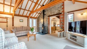A cozy living room with a sofa, a coffee table, and a television. - 3 Bed in Kilkhampton (oc-l27383) (Kilkhampton)