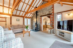 A cozy living room with a sofa, a coffee table, and a television. - 3 Bed in Kilkhampton (oc-l27383) (Kilkhampton)