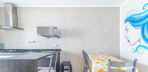 Una cuina moderna amb microones, fogó i campana extractora penjada a la paret.