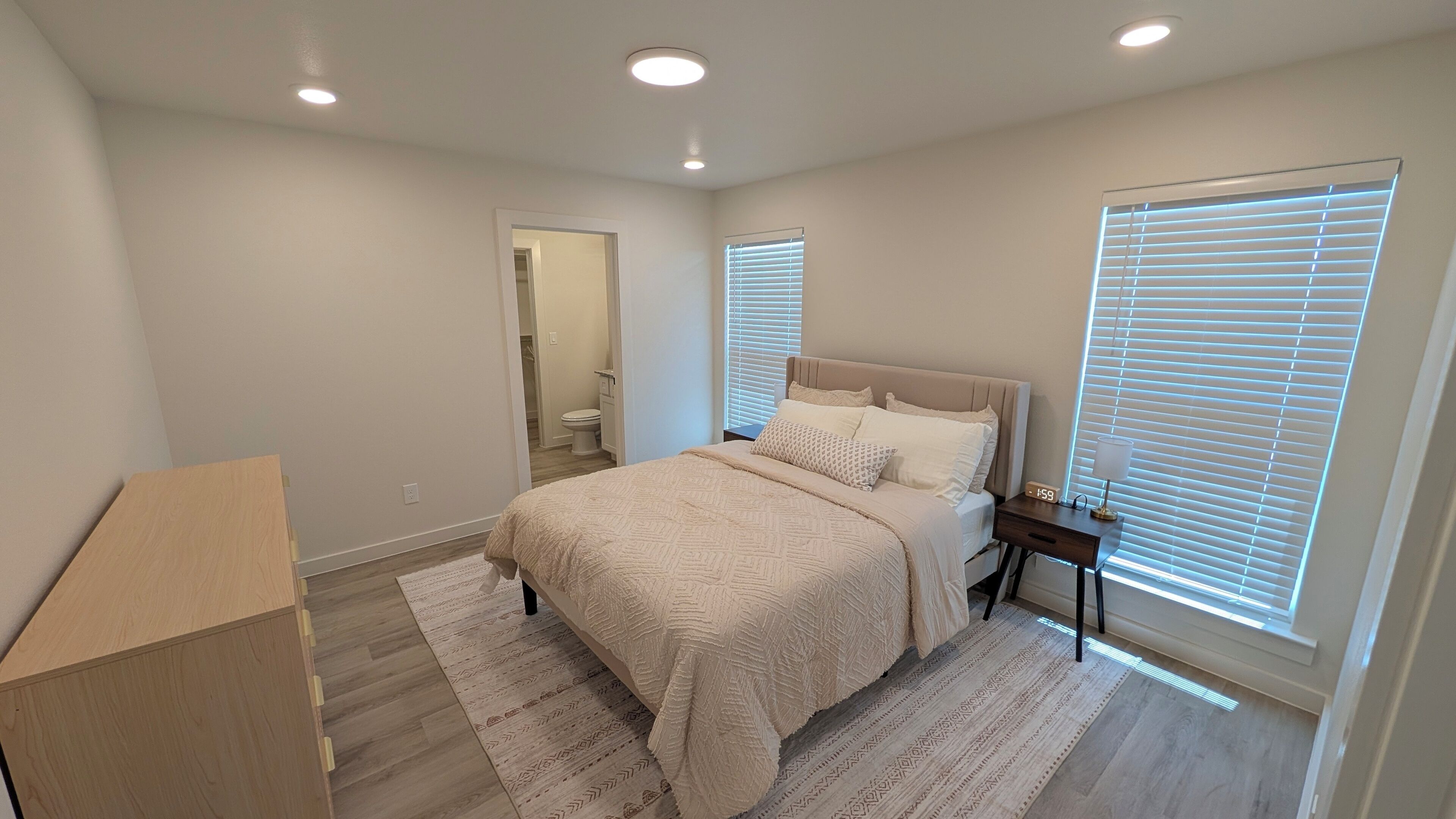 A bedroom with a bed, bedside table, and a nightstand.
