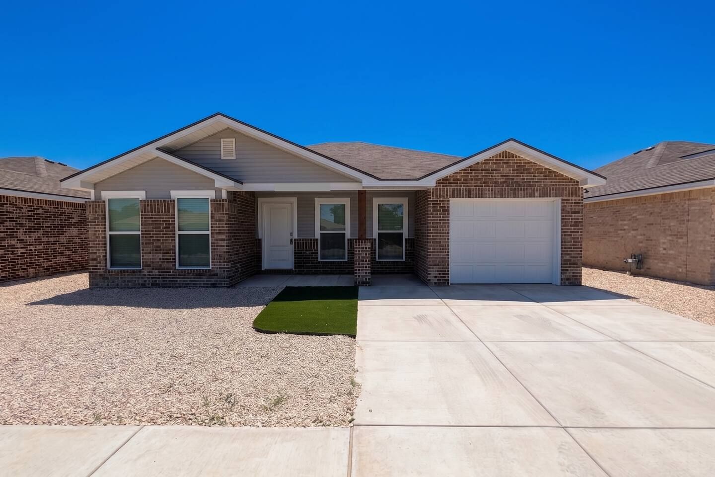 A two-story house with a garage, a front porch, and a small front yard.
