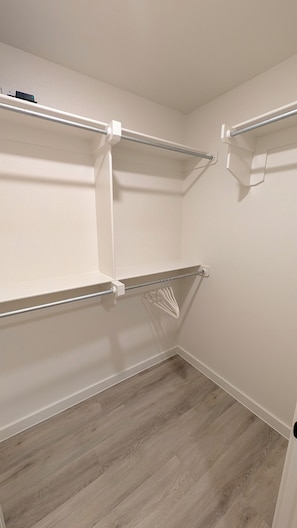 Un placard avec des étagères blanches et un plancher en bois.