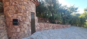 A stone building with a metal gate, a stone wall, and a paved area. - Chic House with a Pool in Cannes (Cannes)
