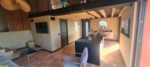 A modern kitchen with a central island, a dining area with a chair, and a view of the outdoors. - Chic House with a Pool in Cannes (Cannes)
