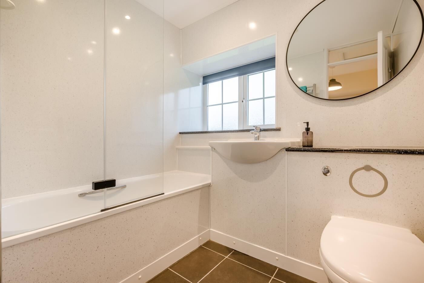 A modern bathroom with a bathtub, sink, and toilet.