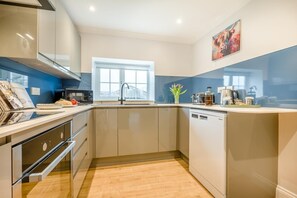 A modern kitchen with a built-in oven, a sink, and a window. - 2 Bed in St. Issey (oc-m31992) (Tredinnick)