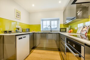 A modern kitchen with a dishwasher, a toaster, and a window. - 2 Bed in St. Issey (oc-c31993) (Tredinnick)