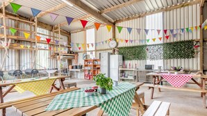 A rustic interior with wooden tables and benches, a clock, and colorful bunting. - 1 Bed in Haverfordwest (oc-b32912) (Dale)