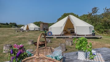 Un terrain de camping équipé de tentes, de tables de pique-nique et de mobilier d’extérieur.