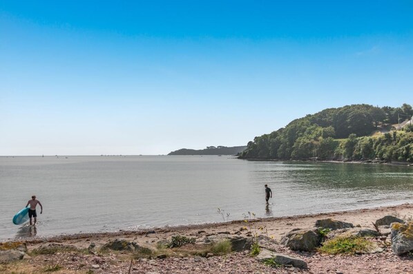 A beach with rocky terrain and a clear sky.