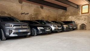 Fila de automóviles estacionados en un garaje con paredes de concreto y un ventanal.