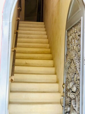 Eine Treppe mit Geländer und einer dekorativen Verkleidung auf der rechten Seite.