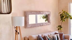 Ein Wohnzimmer mit einer Couch, einer Lampe, einem Tisch und Stühlen.