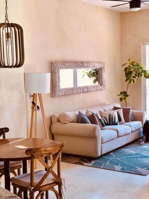 A living room with a sofa, a lamp, a table, and chairs. - Bella Verde, Steps to beach, shops and restaurants (San Francisco)