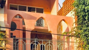 A two-story building with a balcony, a decorative gate, and a parked car. - Bella Rosa, center of town, steps to the beach. (San Francisco)