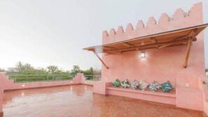 A rooftop terrace with a pink wall, a wooden pergola, and a bench with cushions. - Bella Rosa, center of town, steps to the beach. (San Francisco)