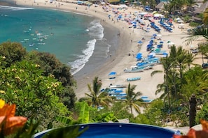 A beach with numerous umbrellas and people, a clear sky, and a view of the ocean. - Casa Kukana- 4 bedrooms - sleeps 9 (Sayulita)