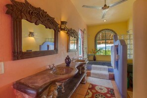 A bathroom with a large mirror, two sinks, and a ceiling fan. - Casa Kukana- 4 bedrooms - sleeps 9 (Sayulita)