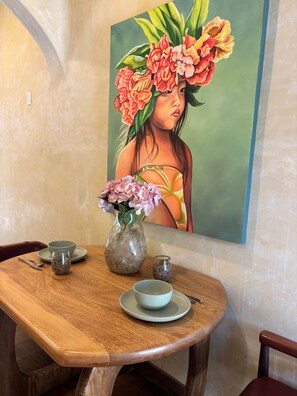 A dining table with a vase of flowers, a bowl, and a cup. - Romantic Jungle Bungalow w/ Pool Near Town & Beach (Sayulita)