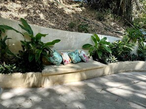 A concrete bench with a series of cushions, surrounded by green plants. - Romantic Jungle Bungalow w/ Pool Near Town & Beach (Sayulita)