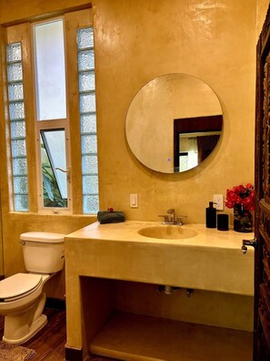 A bathroom with a toilet, a sink, and a mirror. - Romantic Jungle Bungalow w/ Pool Near Town & Beach (Sayulita)