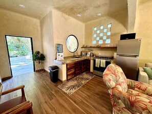 A kitchen with a refrigerator, stove, sink, and a window with a view of greenery. - Romantic Jungle Bungalow w/ Pool Near Town & Beach (Sayulita)