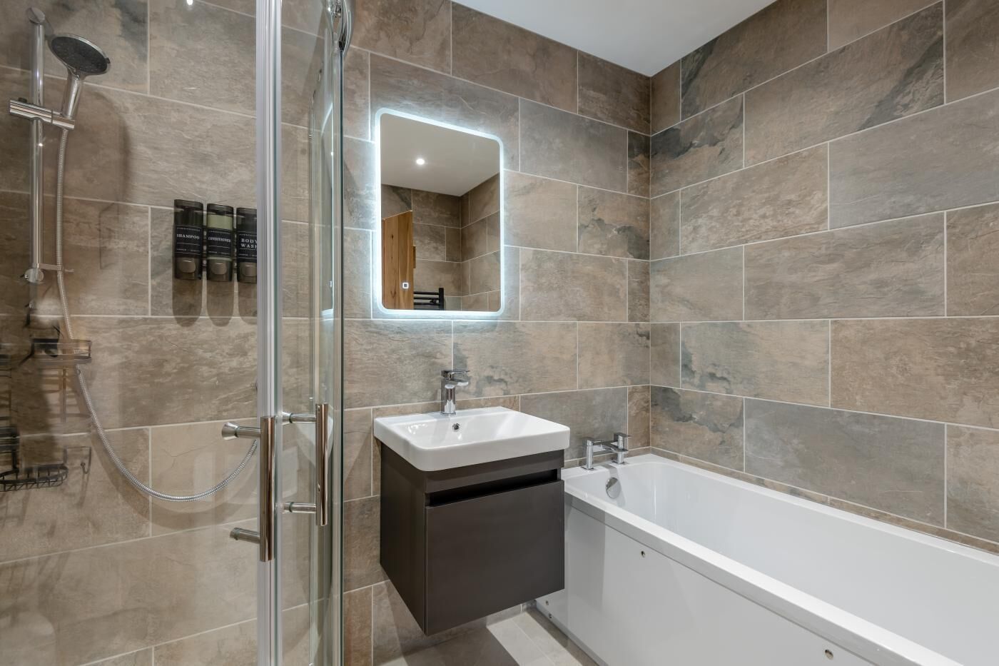 Une salle de bain moderne avec une douche à parois de verre, un lavabo blanc et une baignoire sur pieds.