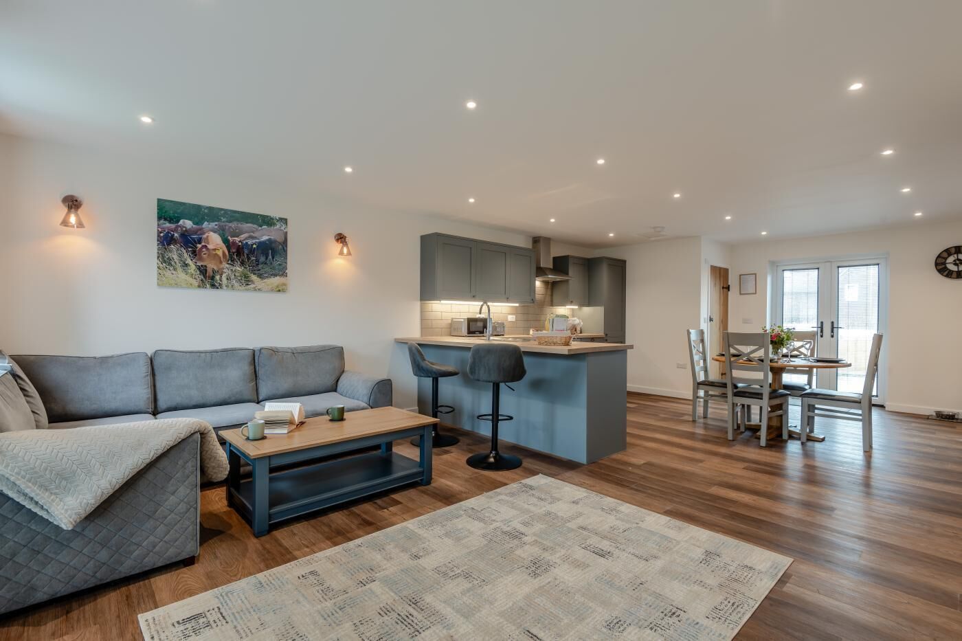 Un espace de vie moderne comprenant un canapé, une table basse et un coin repas avec des chaises et une table.