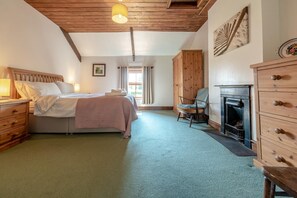 A bedroom with a bed, wooden dresser, chair, and fireplace. - 3 Bed in Parkmill (oc-t36336) (Parkmill)