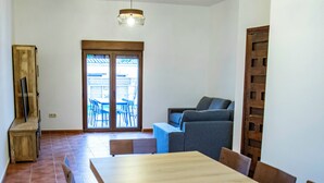 Ein Essbereich mit großem Tisch, Stühlen und einer Couch.