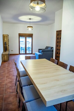 Ein Essbereich mit großem Tisch, Stühlen und einer Couch.