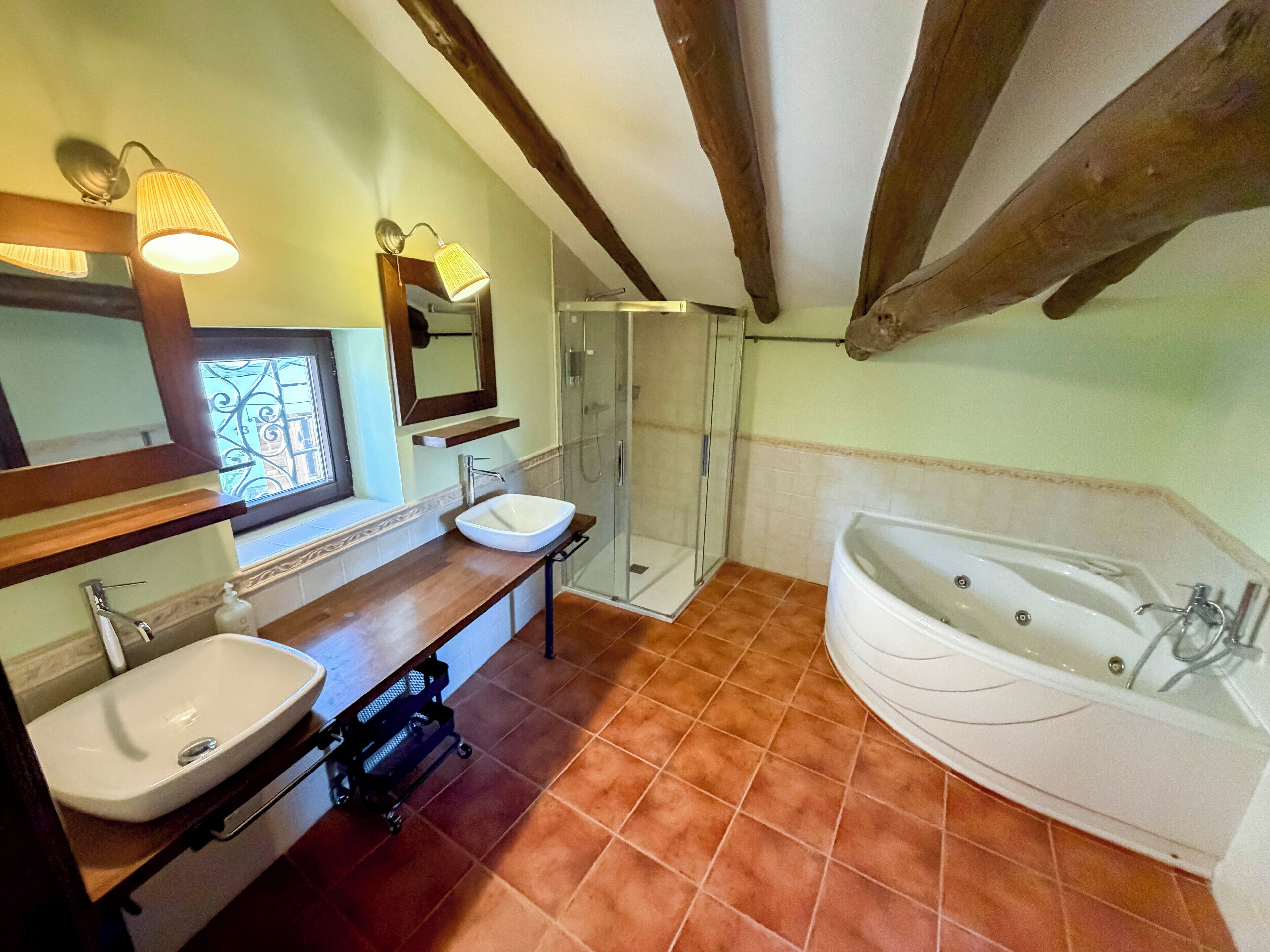 Une salle de bain avec deux lavabos, une douche et une baignoire.