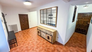 Ein Zimmer mit Fliesenboden, Holzschrank, Spiegel und Heizkörper.