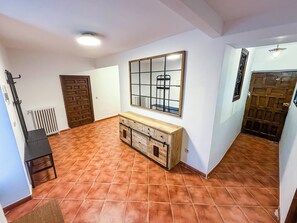 Ein Zimmer mit Fliesenboden, Holzschrank, Spiegel und Heizkörper.
