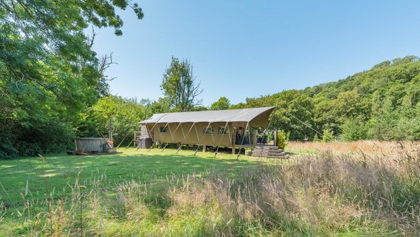 A single-story, open-sided structure with a flat roof, surrounded by a grassy field and dense trees. - 3 Bed in Newcastle Emlyn (oc-a42685) (Cwm-cou)