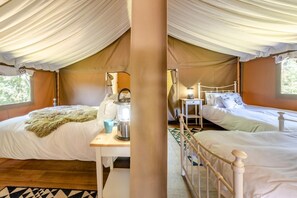 A tented accommodation with two beds, a table with a kettle, and a lamp. - 3 Bed in Newcastle Emlyn (oc-t42686) (Cwm-cou)