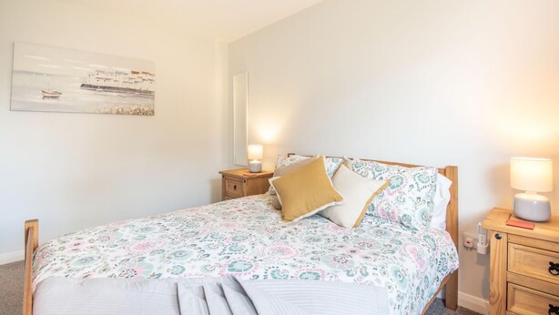 A bedroom with a bed, two bedside tables, a nightstand, a lamp, and a wall-mounted picture. - 3 Bed in Sloothby (oc-i42705) (Sloothby)