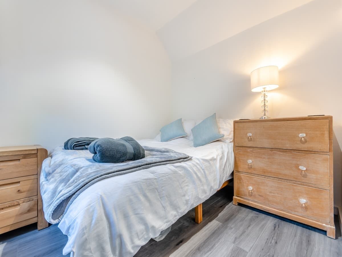 Ein Schlafzimmer mit einem Bett, einem Nachttisch und einer Nachttischlampe.