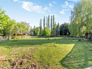A fenced outdoor area with grass, trees, and a wooden structure. - 2 Bed in Burton Pedwardine (oc-t42740) (Burton Pedwardine)