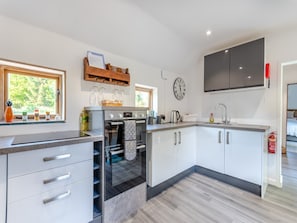 A modern kitchen with a built-in oven, a microwave, and a large window. - 2 Bed in Burton Pedwardine (oc-t42740) (Burton Pedwardine)