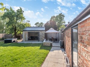 A backyard with a patio, a barbecue area, and a covered seating area. - 2 Bed in Burton Pedwardine (oc-t42740) (Burton Pedwardine)