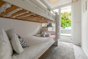 A bunk bed room with a view of a garden through an open door. - 3 Bed in St. Ives (oc-d42669) (St Ives)
