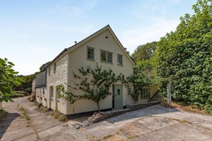 A two-story house with a stone facade, a small front yard, and a staircase leading to the entrance. - 2 Bed in Cotmore (oc-a44749) (Beeson)
